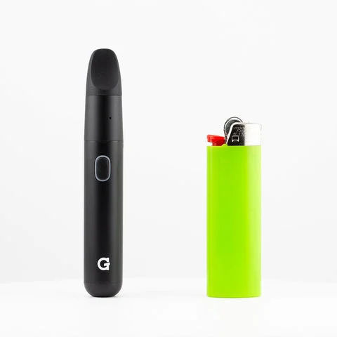 Black vape pen standing upright next to a bright green lighter, shown side by side for size comparison.